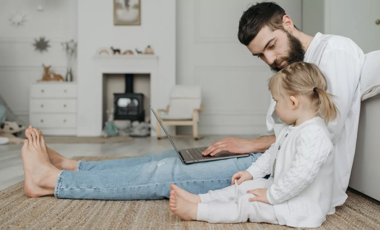 ojciec z córeczką przy laptopie