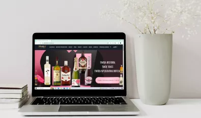 laptop z zdjęciem strony z alkoholami stojący na biurku strona główna