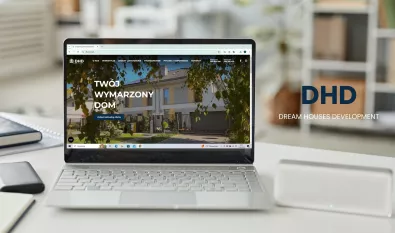 laptop z zdjęciem domu na biurku i logo dhd